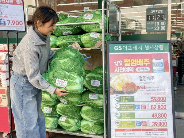 GS더프레시 점포 앞에서 모델이 배추를 살펴보고 있다.GS리테일 제공.