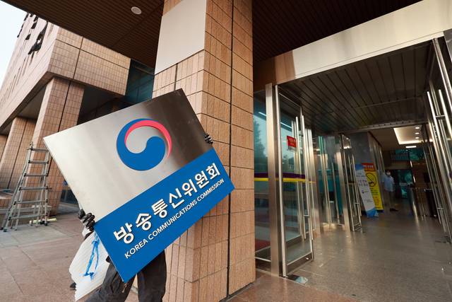 지난달 1일 정부과천청사 방송미디어통신위원회에서 관계자들이 방송통신위원회 현판을 철거한 뒤 옮기고 있다.  연합뉴스