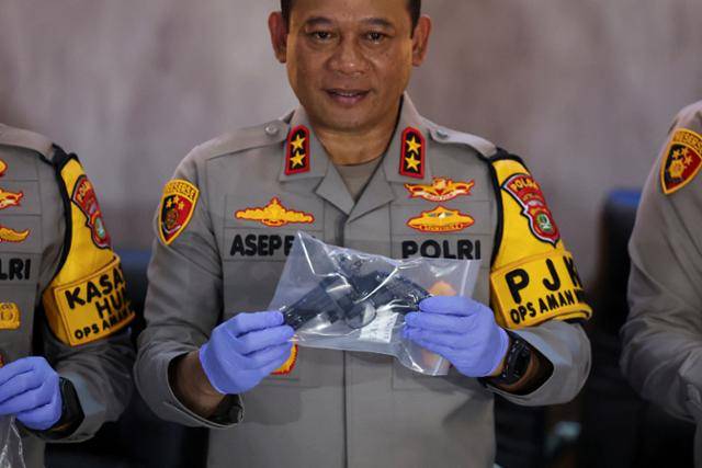 아셉 에디 수헤리 인도네시아 자카르타 경찰서장이 11일 자카르타 경찰본부에서 고교 폭발 사건 현장에서 발견된 증거물인 총기를 보여주고 있다. 자카르타=로이터 연합뉴스