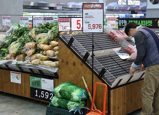 An employee cleans up the vegetable section at a retail store in Seoul on Nov. 10. [YONHAP]