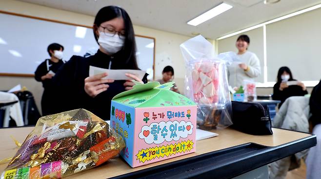 A student checks her test identification slip for the College Scholastic Ability Test (CSAT) at a high school in Incheon on Nov. 12. [YONHAP]