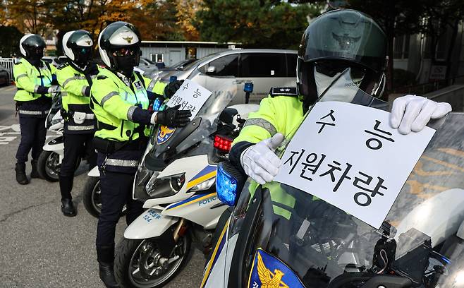 Police officers on Nov. 11 attach signs on their motorbikes that indicate ″CSAT support vehicles″ providing free rides to ensure test-takers arrive on time for the College Scholastic Ability Test (CSAT) in Suwon. [NEWS1]