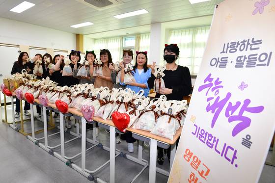 Parents of College Scholastic Ability Test (CSAT)-takers prepare bundles of gifts for their children at a high school in North Gyeongsang on Nov. 11, two days before the exam. [NEWS1]