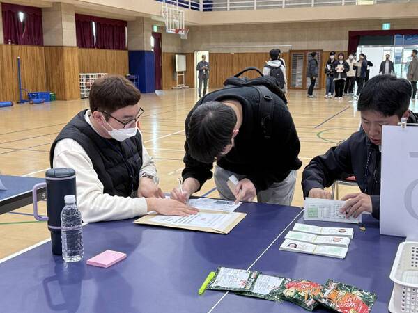 12일 수원북중학교 체육관에서 관계자가 수험표 배부를 위해 수험생 본인 확인 절차를 진행 중이다. 이지민기자