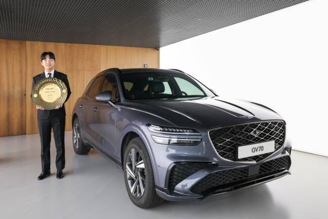 옥태훈이 제네시스 대상 부상으로 받게 된 GV70 옆에서 대상 트로피를 들고 포즈를 취하고 있다. /사진=KPGA 제공