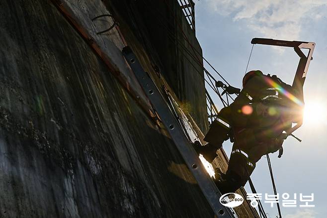 13일 오후 용인시 경기소방학교 붕괴사고훈련장에서 진행된 천공파괴 훈련에 참가한 소방관계자가 레펠에 매달린 상태로 벽에 천공을 내고 있다. 임채운기자