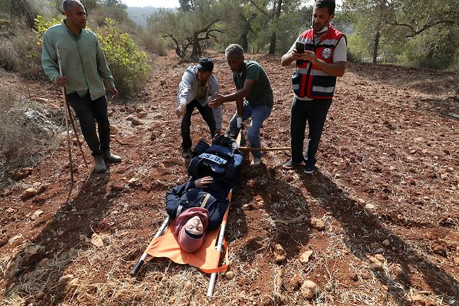 로이터 통신 기자 라닌 사와프타가 8일(현지시간) 요르단강 서안 지구 나블루스 인근에서 이스라엘 정착민들의 공격을 받은 후 의료진에 의해 옮겨지고 있다. 로이터연합뉴스