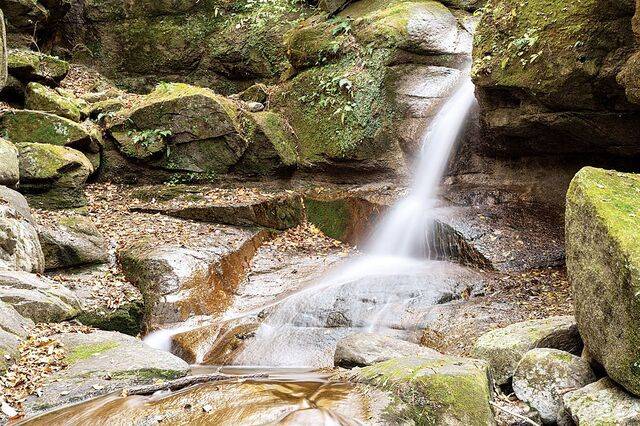 신라 시대 용맹한 청년의 전설을 품은 마수폭포. 암벽 사이로 물줄기가 세차게 쏟아진다.