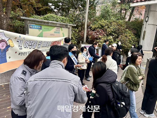 13일 서울 방배경찰서 소속 경찰과 자원봉사자들이 서울 동덕여고 앞에서 수험생들에게 핫팩과 사인펜 등과 함께 격려를 건네고 있다. [김송현 기자]
