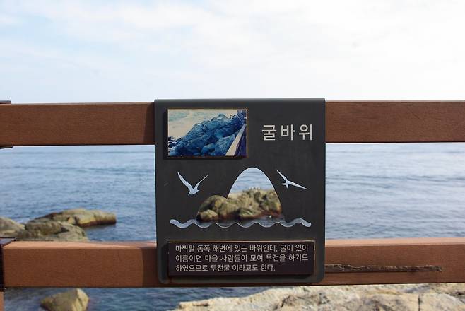 데크 곳곳 안내판을 읽는 재미도 쏠쏠하다. 굴바위 안내판 구멍 사이로 ‘굴바위’가 보인다
