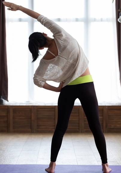 날씬한 젊은 여성이 실내에서 스트레칭을 하고 있다. 겨울에도 꾸준히 운동을 하고, 특히 '슬기로운 음식생활'에 힘써야 흉하게 살찌지 않는다. 사진=게티이미지뱅크