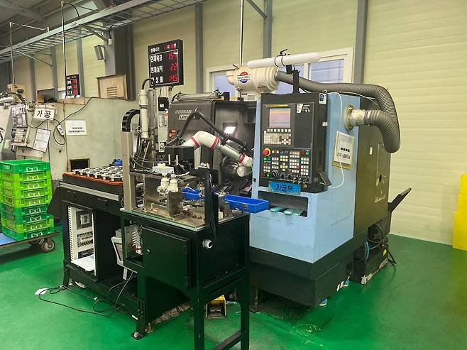 솔루윈스의 AI 비전검사 시스템이 적용된 자동화 생산라인 전경. 협동로봇이 가공 부품을 자동 이송하며 AI 비전카메라가 결함 여부를 판별하고 있다. 솔루윈스의 LVLM 기반 품질검사 솔루션은 작업자의 숙련도에 의존하던 검사 공정을 자동화해 불량 판정 정확도를 98%까지 높였다.