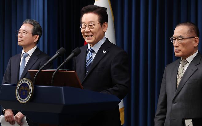 President Lee Jae-myung (center) attends a press conference at the presidential office in Seoul on Friday to announce the joint fact sheet outlining the results of his second summit with US President Donald Trump in Gyeongju on Oct. 29. National Security Adviser Wi Sung-lac (right) and Kim Yong-beom, the presidential chief of staff for policy, stand beside him. (Yonhap)