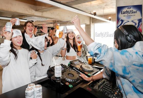 People dance and cheer with Budweiser’s nonalcoholic drink, Budweiser Zero, at “Early Bud,” a morning party hosted by the brand in Itaewon, Yongsan District, central Seoul, on Oct. 26. [BUDWEISER KOREA]