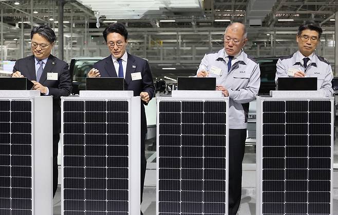 김민석 국무총리가 14일 경기도 화성시 우정읍 기아 오토랜드 화성에서 열린 기아 화성 이보 플랜트 이스트 준공·웨스트 기공식에서 표시석에 서명하고 있다. 왼쪽부터 문신학 산업통상부 차관, 김 총리, 정의선 현대차그룹 회장, 송호성 기아 사장.  연합뉴스