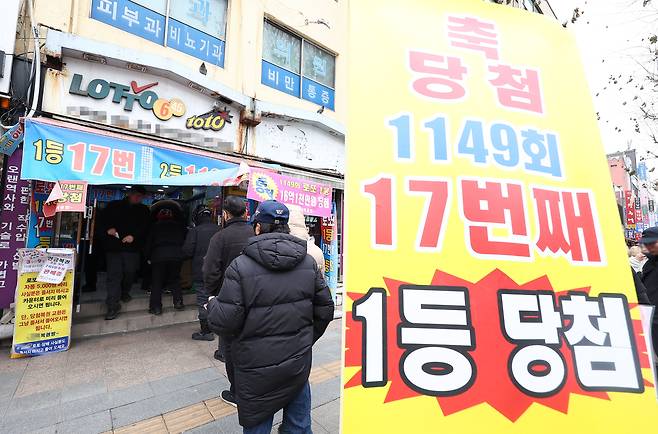 A sign advertising winning the first prize in front of a lottery store known to be a lottery hot spot in Jongno District, central Seoul, on Jan. 30 [YONHAP]