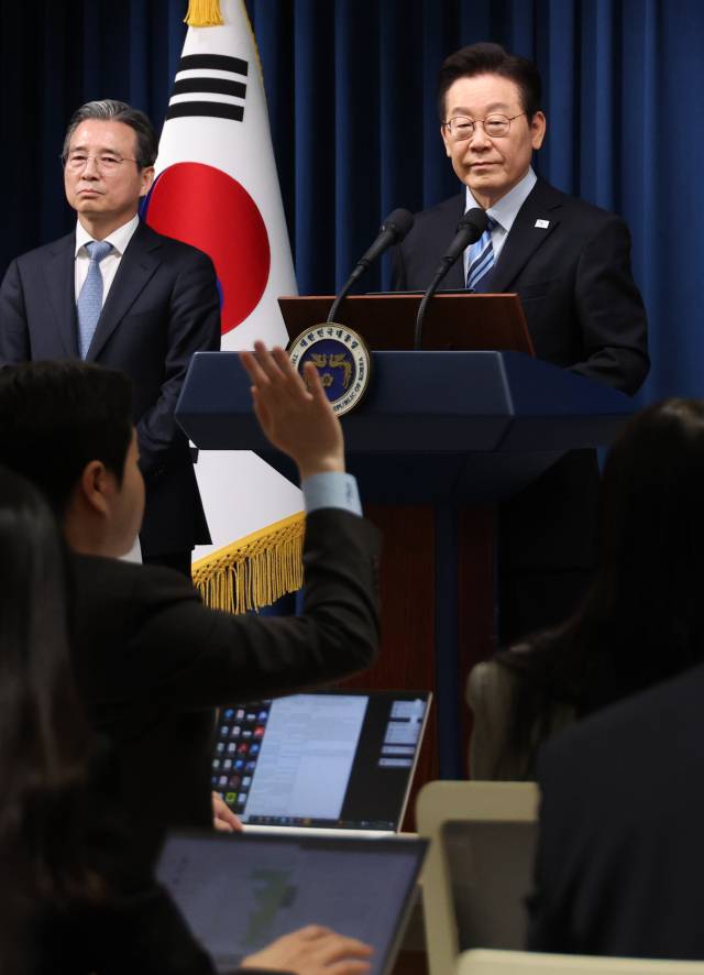 이재명 대통령이 14일 서울 용산 대통령실 기자회견장에서 한미 관세·안보 협상 '조인트 팩트시트'(공동 설명자료) 최종 합의 발표 후 질문을 받고 있다. 왼쪽은 김용범 정책실장. 연합뉴스
