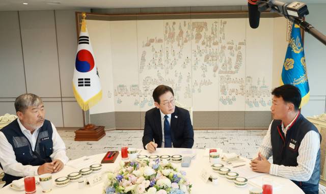 이재명 대통령이 9월 4일 서울 용산 대통령실 청사에서 양대노총 위원장과의 오찬 간담회를 하며 김동명 한국노총 위원장, 양경수 민주노총 위원장의 발언을 경청하고 있다. 연합뉴스