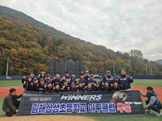 김해삼성초등학교 야구클럽이 '경남 학생체육대회' 우승 기념 현수막을 들고 기념촬영을 하고 있다. 사진=김해시스포츠클럽