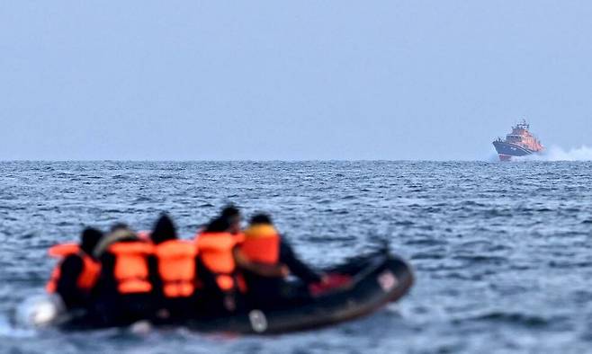 2023년 4월5일 영국 왕립구조협회(RNLI)의 구조 선박 ‘시티 오브 런던 II’가 고무보트를 타고 영국 해협을 건너 영국으로 향하는 이주민들을 향해 다가오고 있다. AFP 연합뉴스