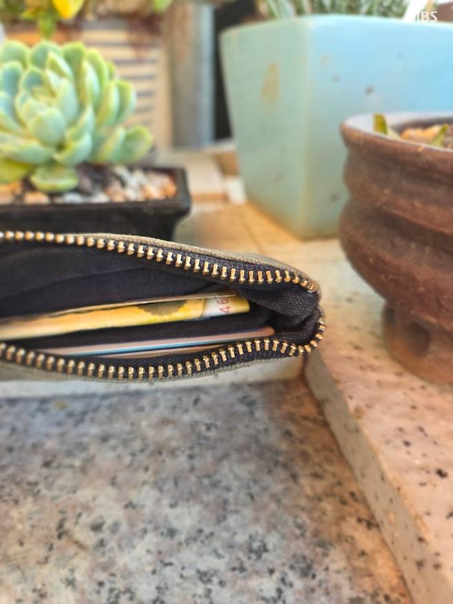 잃어버린 지갑이 집 앞 화분 옆에 놓인 모습