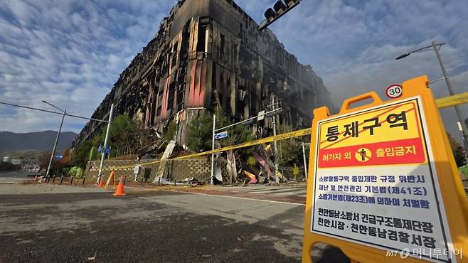 (천안=뉴스1) 이시우 기자 = 충남 천안 동남구 이랜드패션 물류센터 화재 이틀 째인 16일, 화재 현장 주변에 출입 금지 표지판이 설치돼 있다. 소방당국은 대응1단계를 유지한 채 화재 진압을 이어가고 있다.  2025.11.16/뉴스1  Copyright (C) 뉴스1. All rights reserved. 무단 전재 및 재배포,  AI학습 이용 금지. /사진=(천안=뉴스1) 이시우 기자