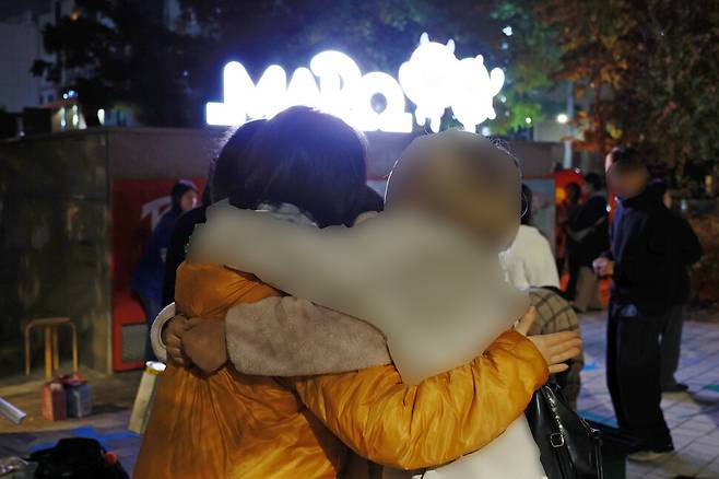 8일 밤 서울 마포구 홍대입구역 6번 출구 인근에서 ‘서울시립십대여성일시지원센터 나무’ 상담 텐트가 접히고 발걸음을 떼지 못하는 청소년들이 활동가(주황색 옷)를 안고있다. 김혜윤 기자 unique@hani.co.kr