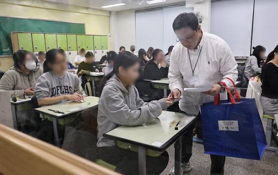 2026학년도 대학수학능력시험(수능)일인 지난 13일 서울 광진구 광남고에서 감독관이 수험생들의 휴대폰을 걷고 있다. 연합뉴스