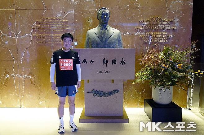 권오갑 HD 현대 명예회장이 현대해상 광화문 사옥 로비에 설치된 현대그룹 창업자 故(고) 정주영 명예회장의 흉상 앞에서 사진 촬영에 임하고 있다. 사진=이근승 기자