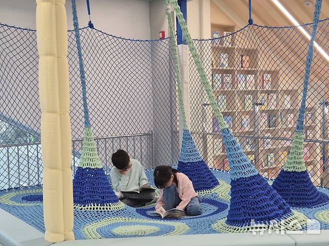 [울산=뉴시스] 구미현 기자 = 울산 북구 당사항 옛 동해분교 자리에 지어진 울산어린이독서체험관. 그물놀이시설에서 독서하는 울산 학생들. 2025.11.17. gorgeouskoo@newsis.com