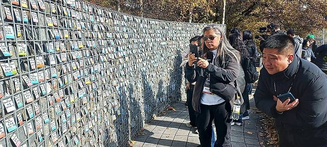 파주 '엄마품동산' 찾은 해외입양인들 '2025 세계한인입양동포대회'에 참가한 입양인들이 11월 11일 경기 파주시 조리읍에 있는 엄마품동산 '기억의 벽'을 방문했다. 이들은 입양인들의 이름이 적힌 카드를 보며 휴대전화로 사진을 찍기도 했다. [연합뉴스 사진]