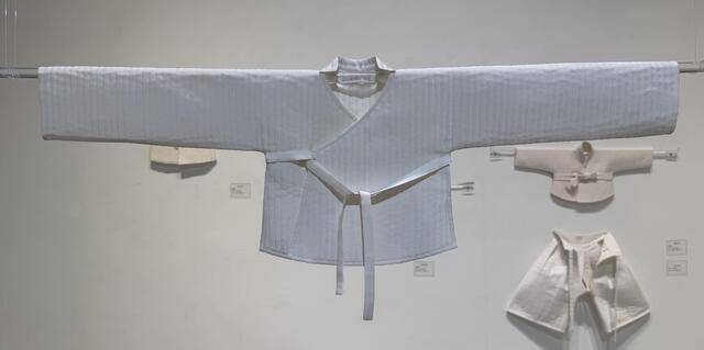 '누비의 시간' 전시장에 디스플레이된 상태의 '배냇 저고리' 재현 작품. 이 배냇 저고리는 17세기 해평윤씨 남아 미이라가 입고 있던 복식을 재현했다. 배를 따뜻하게 하기 위해 저리고 앞은 길고, 뒤는 짧다. 깃은 온 깃이 아니라 목 뒷부분에만 달려있다. 명주 솜누비 작품이다.