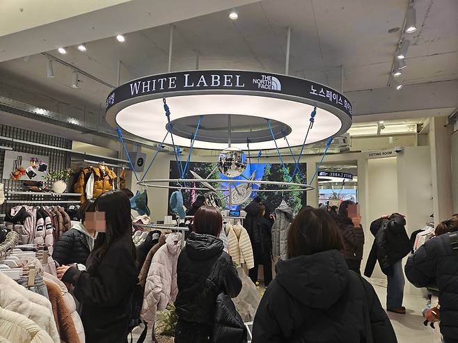 노스페이스 화이트라벨 성수 직영점 내 경량패딩 매대를 찾은 손님들의 모습. /정재훤 기자