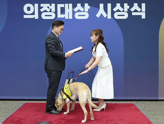 김예지 국민의힘 의원이 지난 11일 서울 여의도 국회에서 열린 5회 대한민국 국회 의정대상 시상식에서 우원식 국회의장으로부터 우수입법의원 의정대상을 받고 있다. 연합뉴스