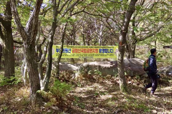 금정산의 금정산성 북문에서 고당봉으로 향하는 등산길에 걸린 금정산국립공원 지정 축하 현수막. 범어사는 이 현수막 첫 번째 명단에 들어갈 정도로 위상이 높다. 김홍준 기자