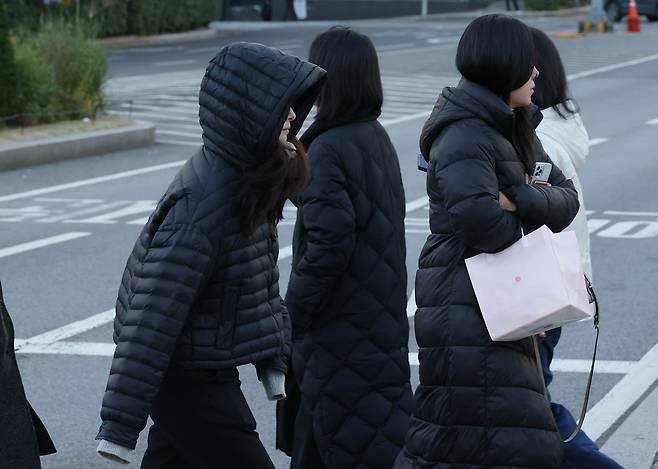 As cold wave advisories were issued for inland areas, including northeastern and southwestern Seoul, on the morning of Nov. 3, commuters hurry through the streets of the capital. (Yonhap)
