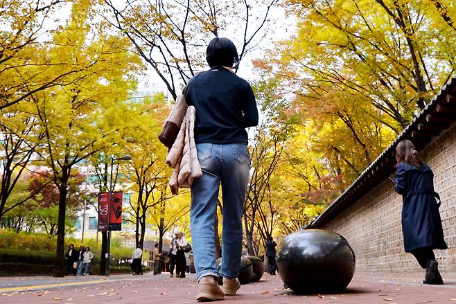 서울 중구 정동길에서 한 시민이 겉옷을 팔에 걸친 채 산책하고 있다. <연합뉴스>