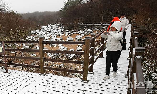 [제주=뉴시스] 우장호 기자 = 올 가을 들어 가장 추운 날씨를 보인 18일 오전 외국인 관광객들이 첫 눈이 쌓인 제주 한라산 1100고지 습지를 감상하고 있다. 2025.11.18. woo1223@newsis.com