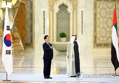 이재명 대통령이 현지시간 18일 아랍에미리트(UAE) 아부다비 대통령궁에서 열린 국빈방문 공식 환영식에서 국기에 경례하고 있다. 오른쪽은 무함마드 빈 자이드 알 나흐얀 UAE 대통령. [사진제공] 대통령실사진기자단