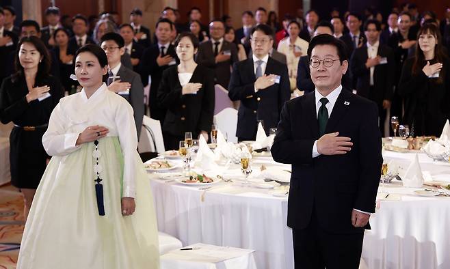 아랍에미리트(UAE)를 국빈 방문 중인 이재명 대통령과 김혜경 여사가 17일(현지시간) 아부다비의 한 호텔에서 열린 동포만찬간담회에서 국기에 경례하고 있다. 연합뉴스