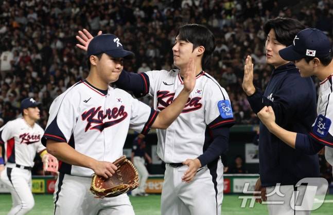 16일 일본전 선발 투수 정우주(왼쪽)가 1회를 마친 뒤 원태인(가운데)의 격려를 받고 있다. /사진=뉴스1