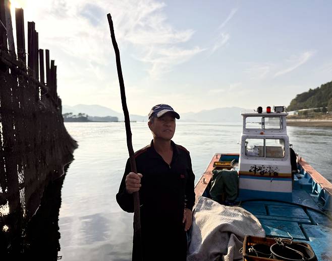 Kim Min-sik, a 66-year-old anchovy fisher, stands on his fishing boat near his jukbangryeom (bamboo fishing weir) in Jijok Strait in Namhae County, South Gyeongsang, on Nov. 5. [LEE SOO-JUNG]