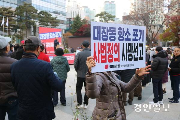 20일 오후 분당 정자역 광장에서 성남시의회 국민의힘협의회 주최로 열린 집회에서 한 참석자가 ‘대장동 항소포기 사법정의 사망선고’라고 적힌 피켓을 들어 보이고 있다. 2025.11.20 성남/김순기기자 ksg2011@kyeongin.com