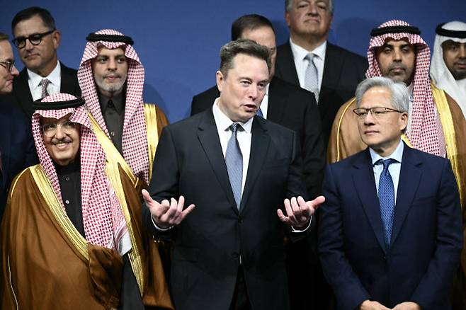 일론 머스크(가운데) 테슬라 최고경영자(CEO)와 젠슨 황(오른쪽) 엔비디아 CEO. (사진=AFP)