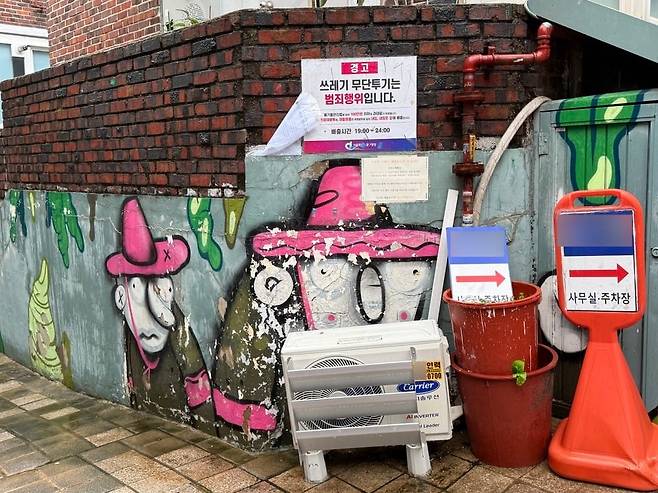 17일 서울 중구 필동예술문화거리 벽화 앞에 쓰레기나 상가 표지판이 놓여 있다. /이호준 기자