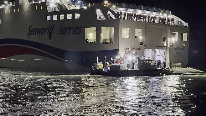 Coast Guard personnel carry out rescue operations at the site where the ferry Queen Jenuvia II ran aground near Sinan County, South Jeolla Province, Wednesday evening. (Mokpo Coast Guard)