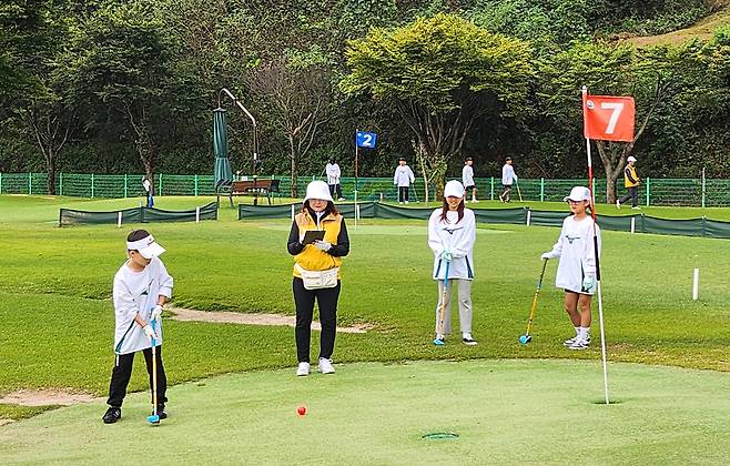 Young students and teachers play park golf at a field in Cheorwon, Gangwon, on Sept. 29. [YONHAP]