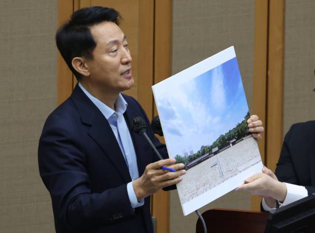 오세훈 서울시장이 18일 서울 중구 서울시의회에서 열린 제333회 정례회 시정질문에 참석, 세운4구역 재개발과 관련된 시뮬레이션 이미지 자료를 들고 질의에 답하고 있다.