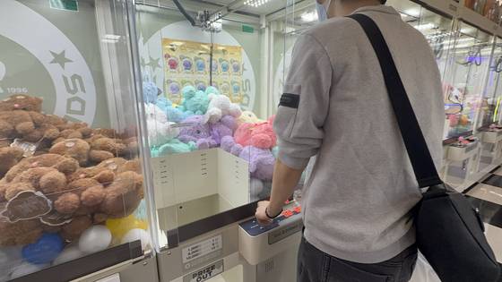 Yoo grabs a bunny plushie using a joystick at Zzang Games arcade in Yongsan, central Seoul. [WOO JI-WON]