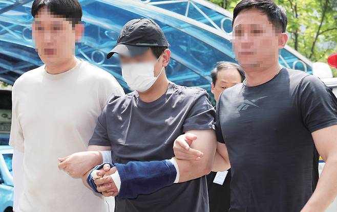 8월21일 경기도 용인의 한 오피스텔 지하주차장에서 30대 여성을 살해한 김씨가 도주한 후 검거돼 경찰서로 압송되고 있다. ⓒ연합뉴스